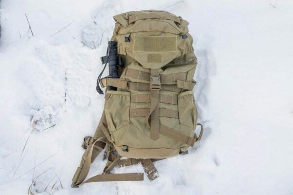 Brown military backpack in snow