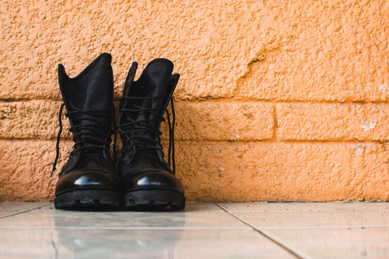 Pair of black tactical boots with a brown background