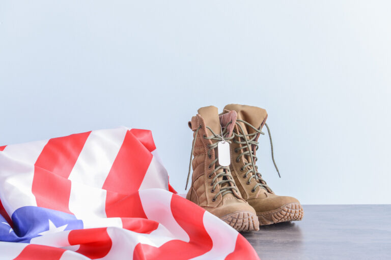 Pair of brown tactical boots alongside American flag Pair of brown tactical boots alongside American flag