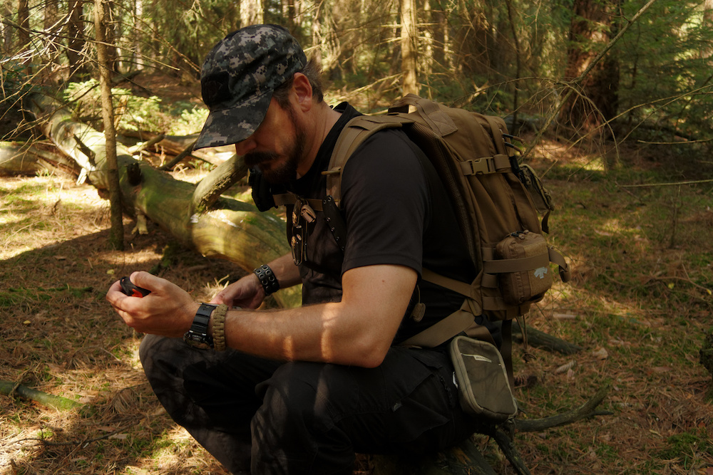 Man wearing tactical gear in forest environment